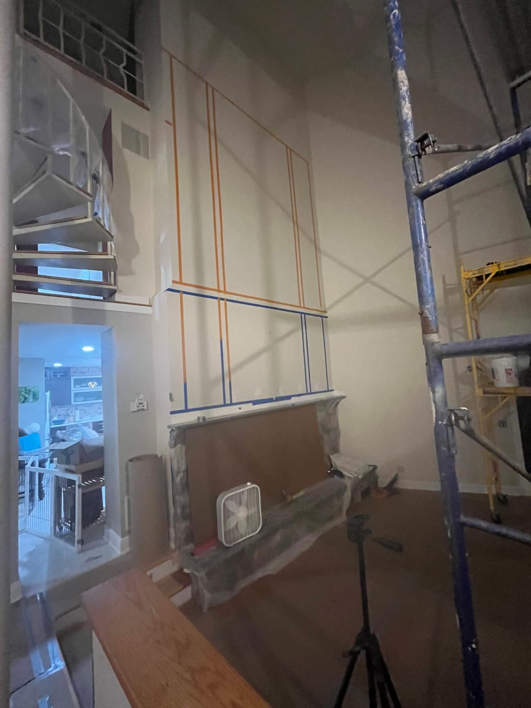 Home renovation in progress with scaffolding and wall framing visible in spacious living area.