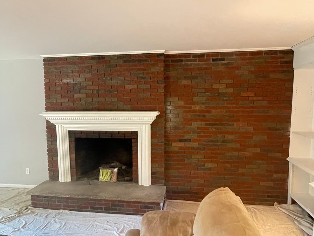 Cozy living room with a brick fireplace and beige couch, ready for interior design updates.