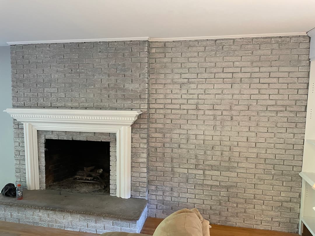 Modern living room with a gray brick fireplace and matching accent wall, showcasing home decor.